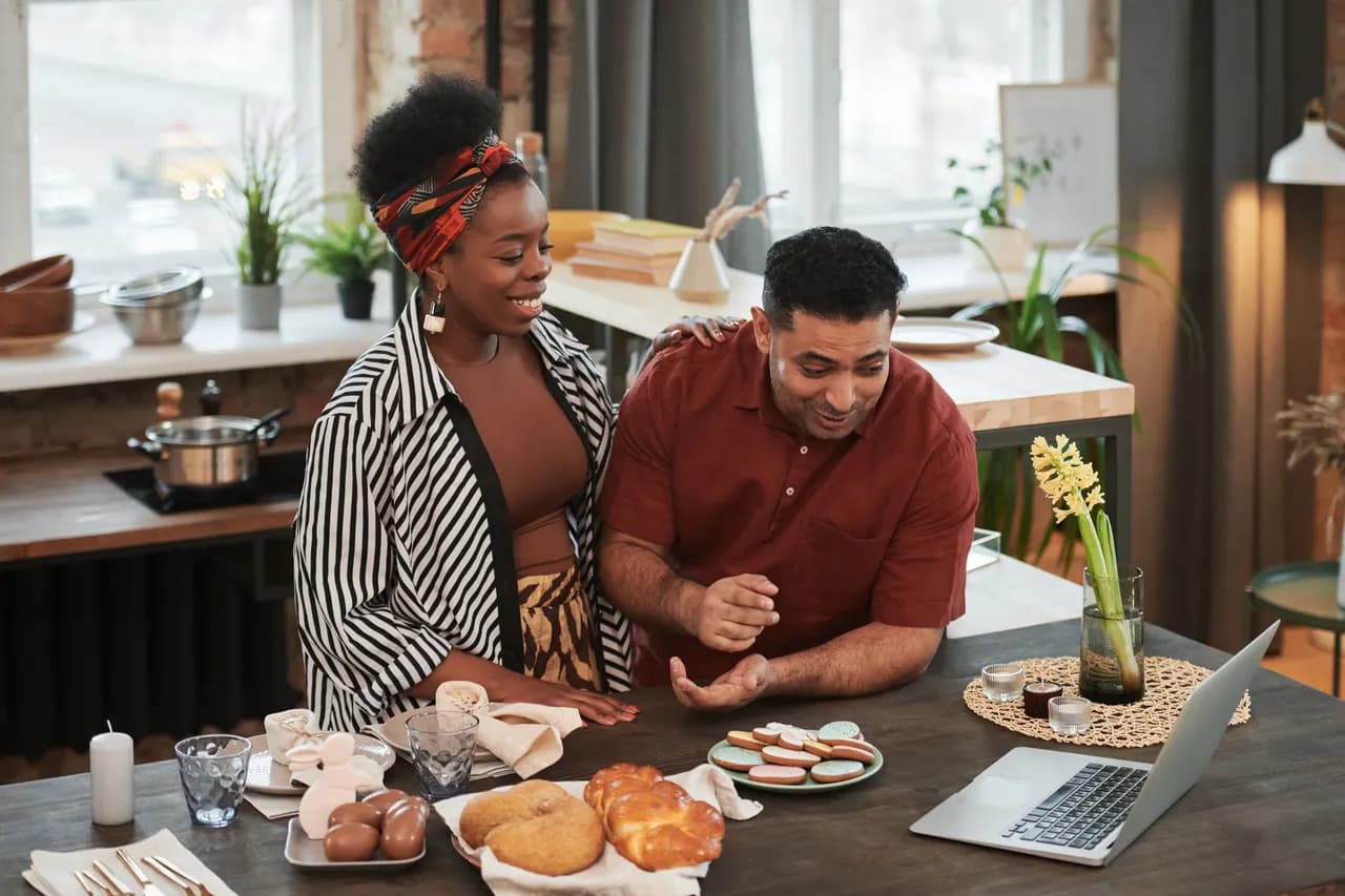 A man at his kitchen table talking to family on a laptop video call